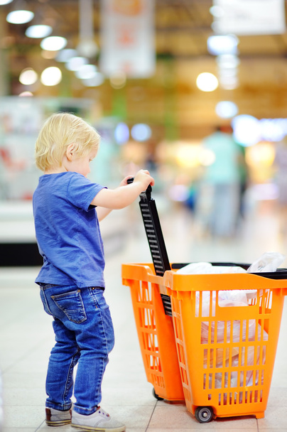 Toddler boy with shopping cart in a supermarket - Фото, зображення