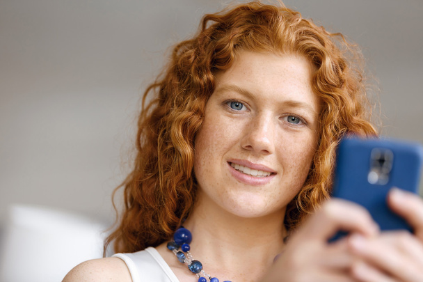 Happy beautiful young businesswoman using smart phone smiling - Fotografie, Obrázek