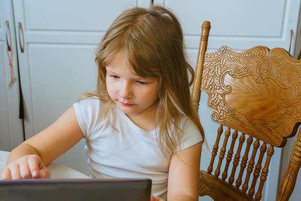 Petite fille mignonne assise à l'aide d'un ordinateur tablette
 - Photo, image