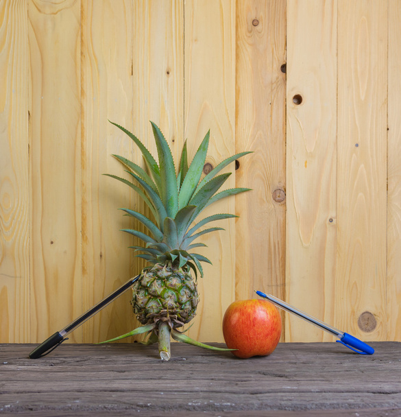 Pen-ananas-elma-kalem ahşap arka plan üzerinde. - Fotoğraf, Görsel