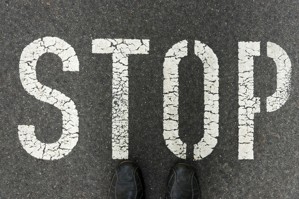 Parola Stop scritto su una strada asfaltata
 - Foto, immagini