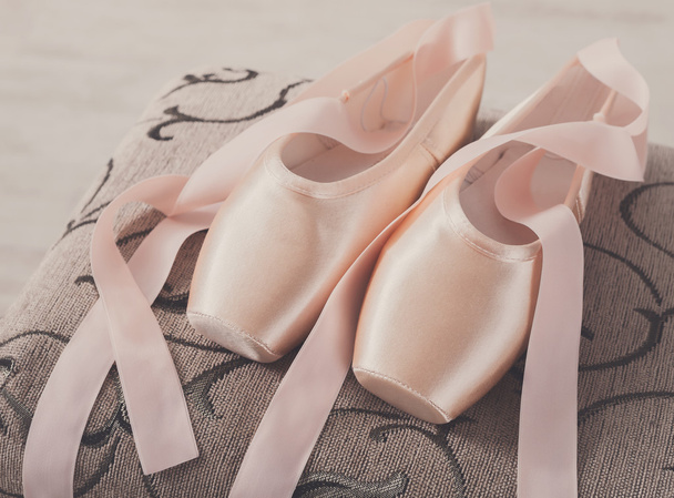 Vaaleanpunainen baletti osoitin kengät tuolilla tausta
 - Valokuva, kuva