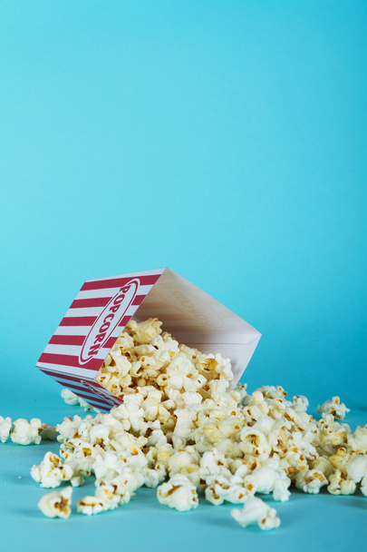 Popcorn emmer tegen een blauwe achtergrond - Foto, afbeelding