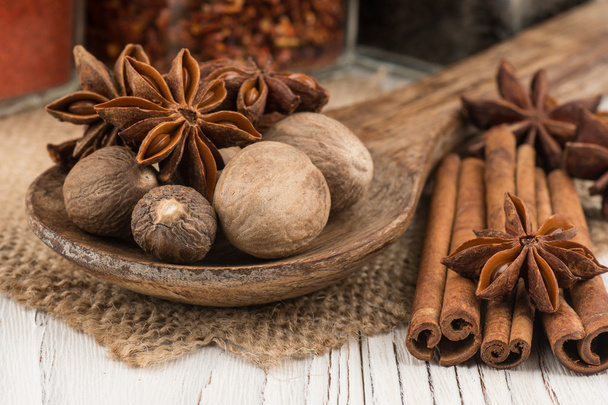 Nutmeg and star anise in the wooden spoon on old wooden table. - Foto, Imagen