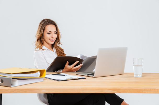 Щаслива красива молода бізнес-леді використовує ноутбук і працює з інструментами
 - Фото, зображення