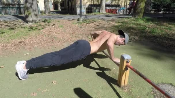 Young man exercising in outdoor gym - Záběry, video
