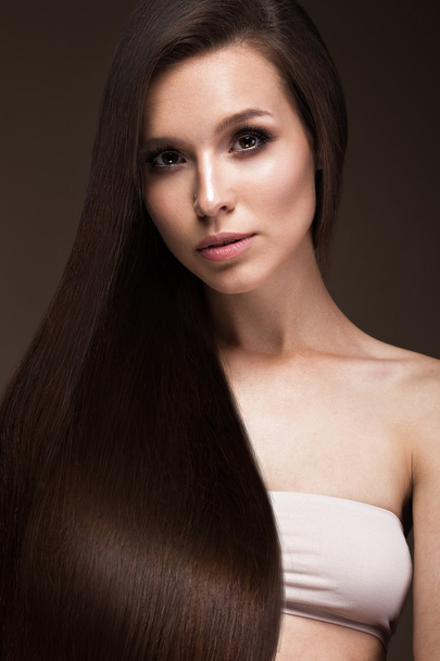 Beautiful brunette girl with a perfectly smooth hair, and classic make-up. Beauty face. - Zdjęcie, obraz