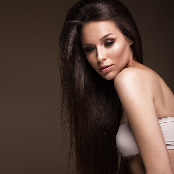 Beautiful brunette girl with a perfectly smooth hair, and classic make-up. Beauty face. - Foto, Imagem