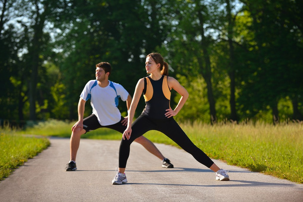 Couple doing stretching exercise after jogging - Foto, imagen