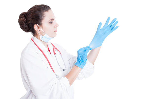 Young female doctor putting gloves on - Φωτογραφία, εικόνα