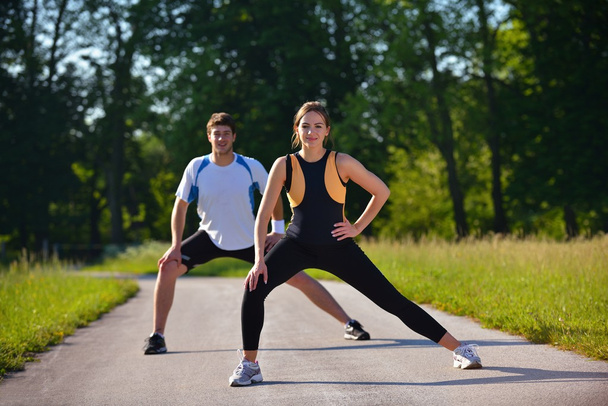 Couple doing stretching exercise after jogging - Fotó, kép