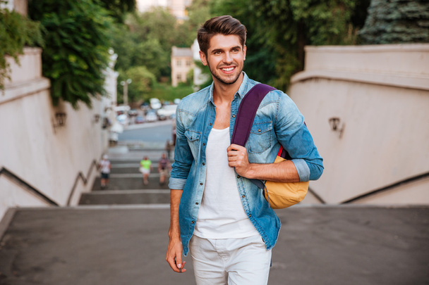 Cheerful young man enjoying walk the city - Fotoğraf, Görsel