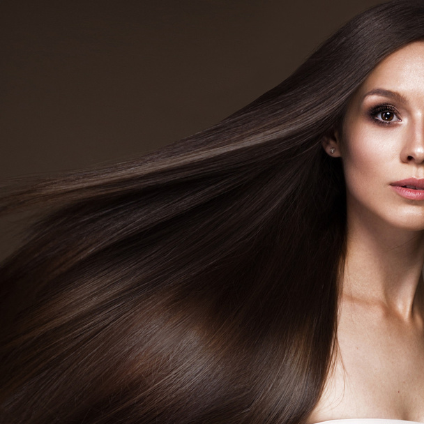 Beautiful brunette girl in move with a perfectly smooth hair, and classic make-up. Beauty face. - Zdjęcie, obraz