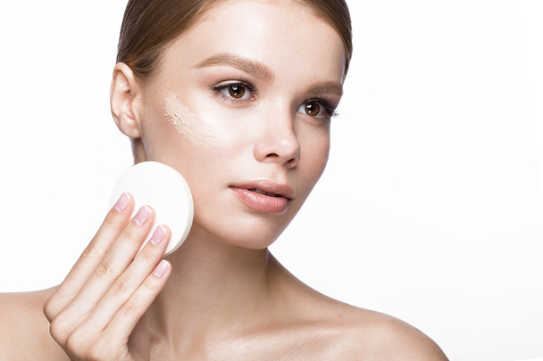 Beautiful young girl with sponge for application make-up and French manicure. Beauty face. - Foto, Imagen