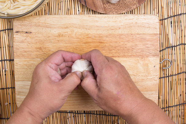 Chef-kok peeling knoflook met hand  - Foto, afbeelding