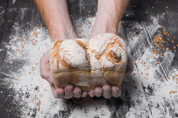 Fondo concepto panadería. Las manos sostienen pan.
 - Foto, Imagen