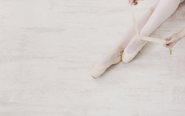 Балерина надевает пуанты балетные туфли, изящные ноги
 - Фото, изображение