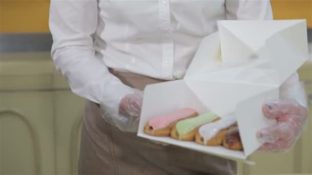 Woman shows the box with brewing cakes - Video