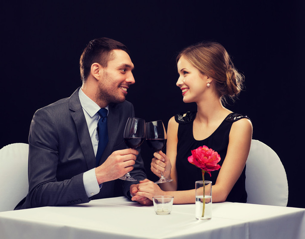young couple with glasses of wine at restaurant - Foto, imagen
