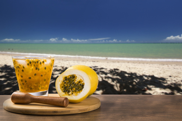 Φρέσκο ποτό που γίνεται με φρούτα του πάθους Caipirinha στην παραλία πίσω - Φωτογραφία, εικόνα
