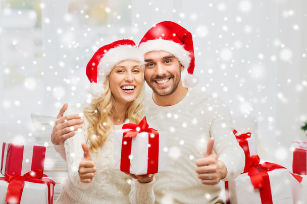 happy couple with christmas gifts and thumbs up - Foto, immagini