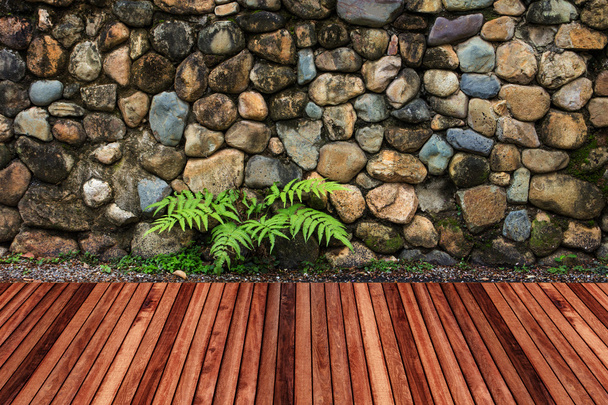 Wooden decking with stone wall background. - Photo, Image