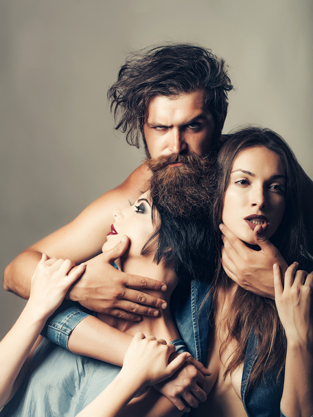 Bearded man with two attractive young girls - 写真・画像