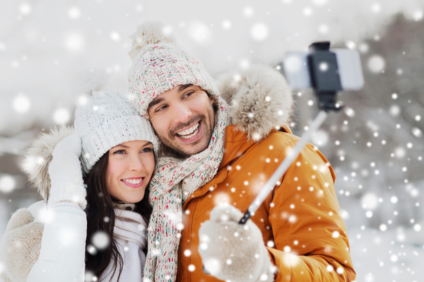 happy couple taking selfie by smartphone in winter - Fotó, kép
