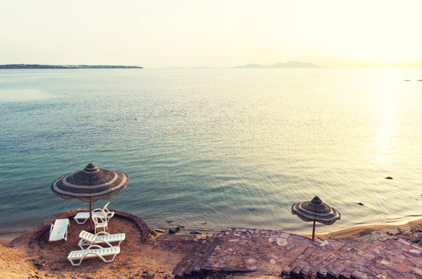 Sonnenschirme am Strand im Ferienort Ägypten. klares Wasser des roten Meeres. Beliebtes Urlaubsziel der Europäer. - Foto, Bild