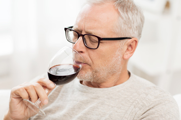 hombre mayor beber vino tinto de vidrio en casa
 - Foto, Imagen