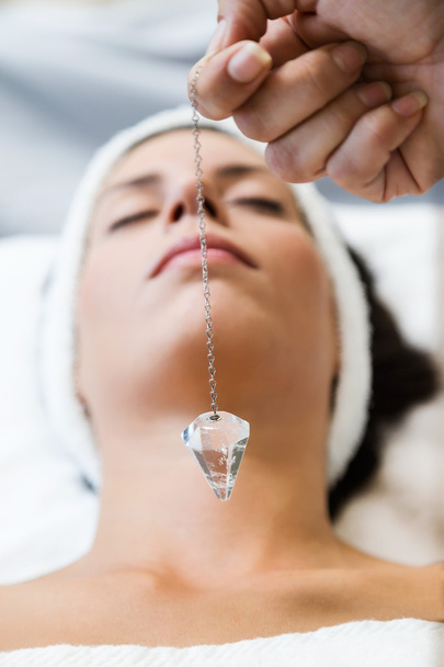 Beautiful young woman receiving gemstone therapy in spa. - Zdjęcie, obraz