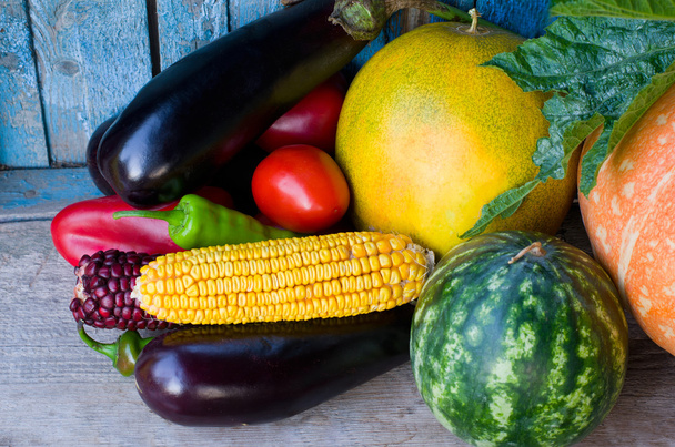Zátiší z podzimní zeleniny: lilek, kukuřice, meloun, meloun a rajčata, starý dřevěný stůl - Fotografie, Obrázek