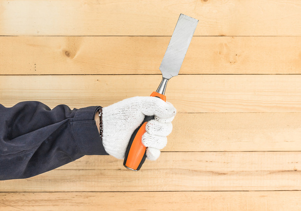 Hand in glove holding chisel - Photo, Image