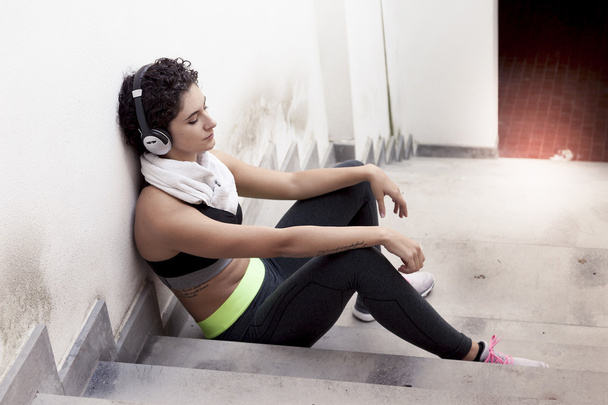 young female runner relaxing listening to music from headphones - Valokuva, kuva