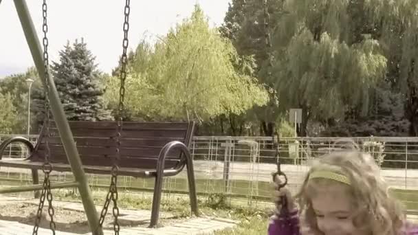 Szczęśliwa dziewczyna na plac zabaw dla dzieci - Materiał filmowy, wideo