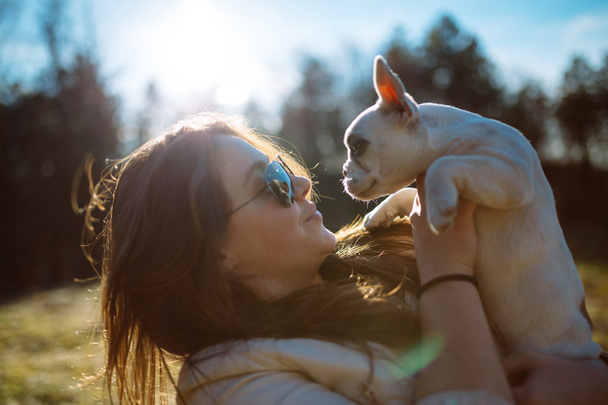girl in sunglasses playing with puppy - Photo, Image