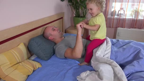 Menina criança feliz montando papai na cama. Criança gosta de tempo com o pai
 - Filmagem, Vídeo