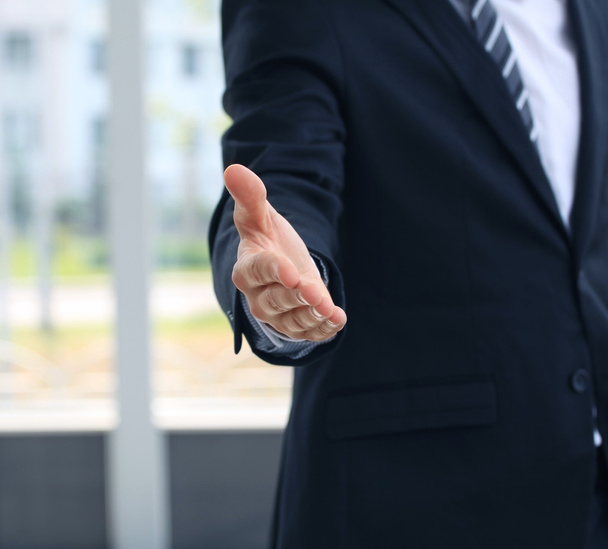 Бизнесмен с открытой рукой, готовый заключить сделку - Фото, изображение