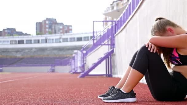 Genç kız atlet nefes alarak yorgun bitkin bir stadyum üzerinde çalıştırdıktan sonra hayal kırıklığına - Video, Çekim