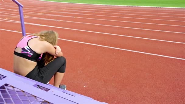 Teenager girl athlete taking breath tired exhausted disappointed after running on a stadium - Footage, Video