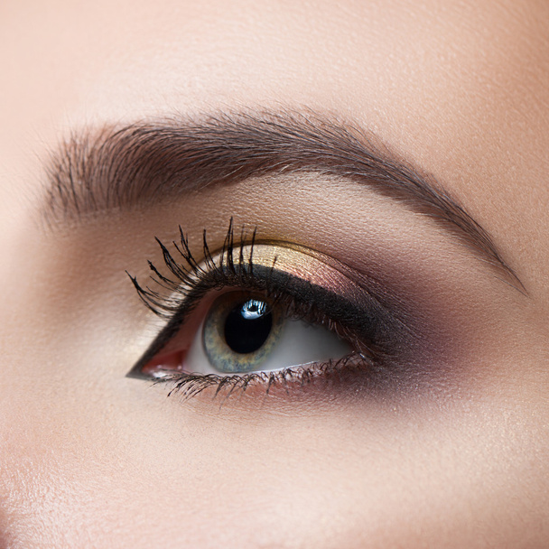 Female eye close-up. Macro. Perfect makeup and eyebrows. Beautiful gray eyes - Foto, imagen