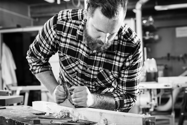 Tischler arbeiten in Werkstatt mit Hobel auf Holzplanke - Foto, Bild
