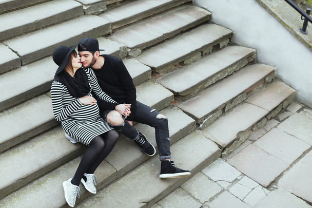 Man and pregnant woman sitting on stairs - Photo, Image