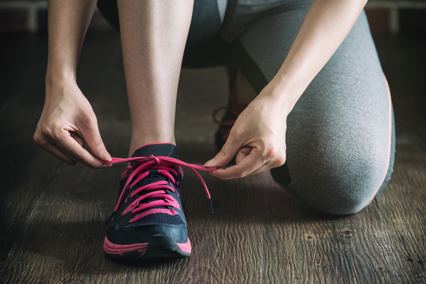 knee down with tie sneakers shoestring before fitness exercise - Fotó, kép