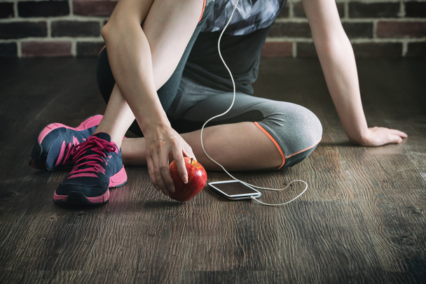 take rest listening to music eating apple after fitness exercise - Valokuva, kuva