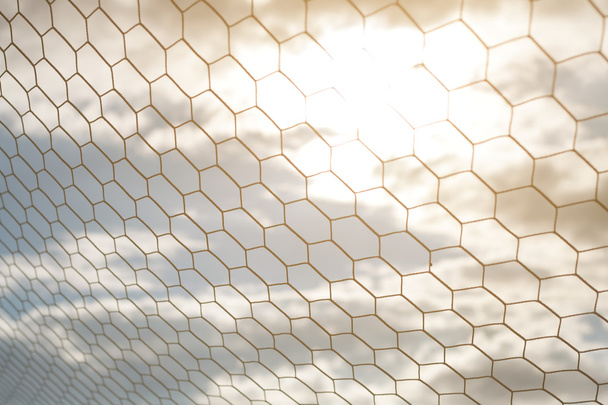 Detalhe da rede de futebol com luz solar no fundo do campo
 - Foto, Imagem