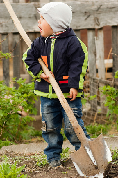 Little boy with a spade in the garden - Фото, зображення