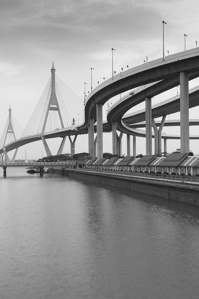 Μαύρο και άσπρο, κρεμαστή γέφυρα συνδέουν τον αυτοκινητόδρομο riverfront - Φωτογραφία, εικόνα