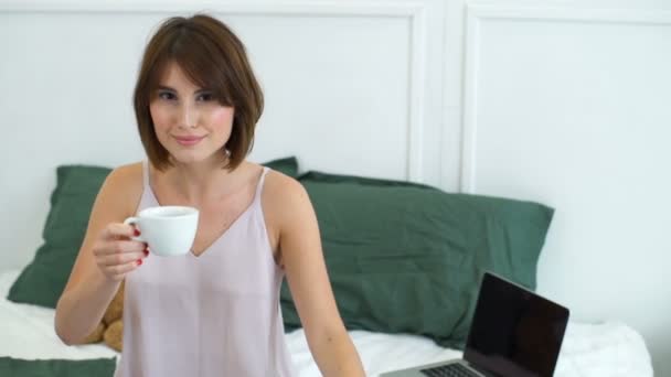 beautiful woman drinking coffee in bed slow motion - Filmati, video