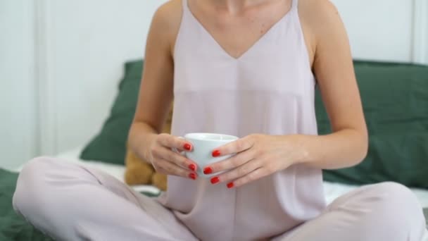 close up dolly shot of woman drinking coffee in bed - Πλάνα, βίντεο
